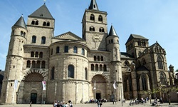 Touristen stehen vor der eindrucksvollen, im gotischen Stil gestalteten Liebfrauenkirche von Trier.