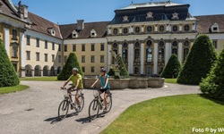 Ein Radlerpärchen beim Chorherrenstift von St. Florian in der Nähe von Linz.