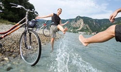 Ein Radlerpärchen nutzt eine kurze Pause für eine Wasserschlacht in der Donau.