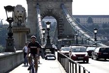 Radfahrer, Fußgänger und Autos auf der Kettenbrücke in Budapest.