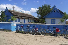 Ein paar Räder stehen an einem blauen Bretterzaun am Fischerdorf Lété im Donaudelta