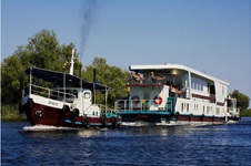Das Floßhotel wird von einem Schiff über die Donau gezogen