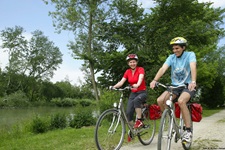 Zwei Radler fahren im Donaudelta auf einem Schotterweg der Donau entlang