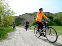 Drei Fahrradfahrer radeln auf einem Schotterweg