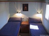 Eine Zwei-Bett Kabine auf dem Floßhotel mit zwei getrennten Bett - in der Mitte steht ein Nachttischchen