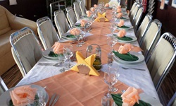 Der schön eingedeckte Tisch der Hotelboots im Donaudelta mit weiß-rosé farbenen Tischdecken