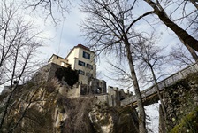 Blick auf ein Haus auf einem Fels, das mit einer Brücke verbunden ist, am Donau-Radweg