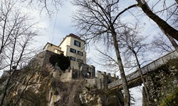 Blick auf ein Haus auf einem Fels, das mit einer Brücke verbunden ist, am Donau-Radweg