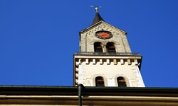 Ein Kirchturm mit Uhr von unten nach oben fotografiert