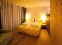 Blick in ein abendlich beleuchtetes Doppelzimmer mit Sofa im Hotel Herrmann in Münsingen