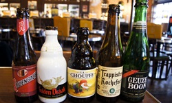 Verschiedene leere Bierflaschen auf einem Tisch im Salon der MS Sarah zeigen die Vielfalt der an Bord erhältlichen Getränke.