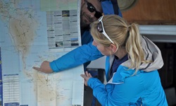 Eine Reiseleiterin zeigt den Gästen bei der täglichen Radtourenbesprechung auf einer Karte, wie die heutige Etappe verläuft.