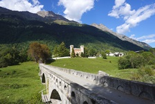 Herrliches Bergpanorama im Valchiavenna; im Vordergrund eine Steinbrücke, in der Bildmitte ist der Palazzo Castelmur zu erkennen.