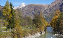 Traumhafter Blick auf die bei Obergesteln ruhig dahinfließende, von teilweise schneebedeckten Bergen überragte Rhone.