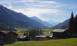Typische Walliser Landschaft mit Chalets und Bergen bei Muenster.