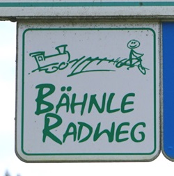 Weißes Straßenschild mit grüner Aufschrift "BÄHNLE RADWEG"