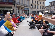 Eine Radlergruppe genießt ihre Pause in einem Café und prostet sich mit einem kühlen Bier zu.