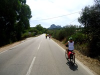 Eine Radlergruppe durchquert die Gallura auf einer asphaltierten Straße.