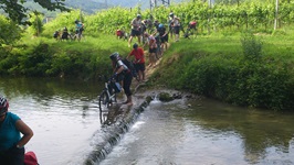 Eine Radlergruppe auf der Gruppenreise Venetien schiebt ihre Räder durch einen kleinen Fluss