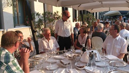 Guido Sackmann steht an einem gedeckten Tisch in einem Hotel bei Gästen der Gruppenreise Venetien