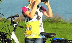 Eine Frau steht am Fahrrad und macht ein Foto der Landschaft der Mecklenburgische Seenplatte