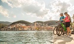 Zwei Mountainbiker stehen an der Promenade der Stadt Pucisca auf der Insel Brac in Süddalmatien