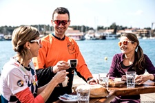 Ein Mann und zwei Frauen gönnen sich in einem süddalmatinischen Hafen eine Kaffeepause.