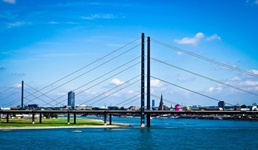 Die Oberkasseler Brücke erhebt sich vor der Skyline von Düsseldorf.