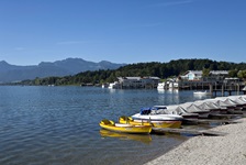 Blick auf angelegte Boote am Chiemsee - im Hintergrund die Alpenkulisse