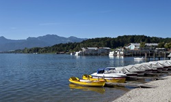Blick auf angelegte Boote am Chiemsee - im Hintergrund die Alpenkulisse