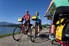 Radfahrer auf dem gefplasterten (Rad-)Weg entlang des Chiemsees