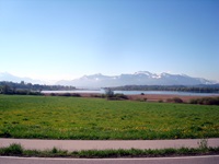 Blick über Wiesen, Felder, einen See und die traumhafte Alpenkulisse in Bayern