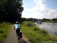 Fahrradfahrer radelt einem Fluss auf der Drei-Länder Weintour entlang