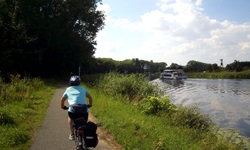 Fahrradfahrer radelt einem Fluss auf der Drei-Länder Weintour entlang
