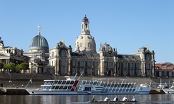 Ein Passagierschiff und ein Ruderboot passieren das Dresdner Elbufer mit dem Lipsius-Bau, der heute die Hochschule für Bildende Künste beherbergt, und der Frauenkirche.