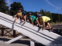 Eine Gruppe Radreisender sitzen auf der weißen Brücke in der Spindlermühle