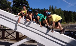 Eine Gruppe Radreisender sitzen auf der weißen Brücke in der Spindlermühle
