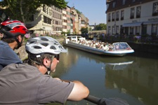 Zwei Radler beobachten ein Schiff auf dem Ill-Kanal in Straßburg.