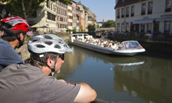 Zwei Radler beobachten ein Schiff auf dem Ill-Kanal in Straßburg.