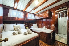 Blick in eine Dre-Bett-Kabine und dem dazugörigen Bad mit Dusche auf dem Deluxeschiff Erato