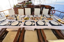 Ein reich gedeckter Tisch auf dem Deck des Deluxschiffes Erato