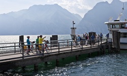 Eine Gruppe Radfahrer wartet am nördlichen Ufer des Gardasees darauf, an Bord des Schiffes gehen zu können, das sie zum Südufer bringt.