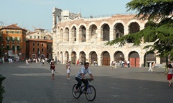 Fußgänger und Radfahrer tummeln sich vor dem weltberühmten Amphitheater von Verona.
