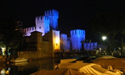 Das Castello Scaligero in Sirmione wird abends in verschiedenen Farben angestrahlt.