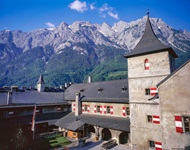 Die Festung Hohenwerfen mit ihren in den österreichischen Landesfarben gestrichenen Fensterläden vor einer herrlichen Bergkulisse.