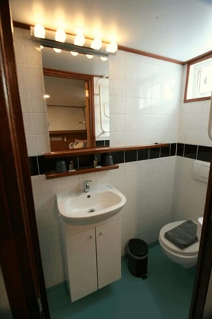 Blick in ein Badezimmer mit Waschbecken, Spiegel und Toilette auf der MS La Mar
