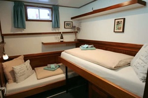 Blick in eine Twin Kabine mit einem Bett am Boden und einem erhöhtem Klappbett auf der MS La Mar