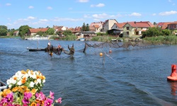 Zum Trocknen aufgehängte Fischernetze vor einem Dorf in Brandenburg.