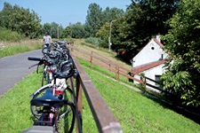 Fahrräder lehnen am Geländer eines Deichs in Flandern.