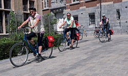 Drei Radfahrer in einer flandrischen Stadt.
